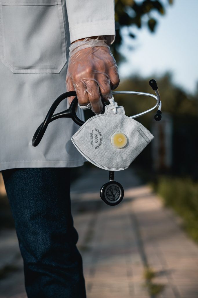 close up of doctor holding mask and stethoscope