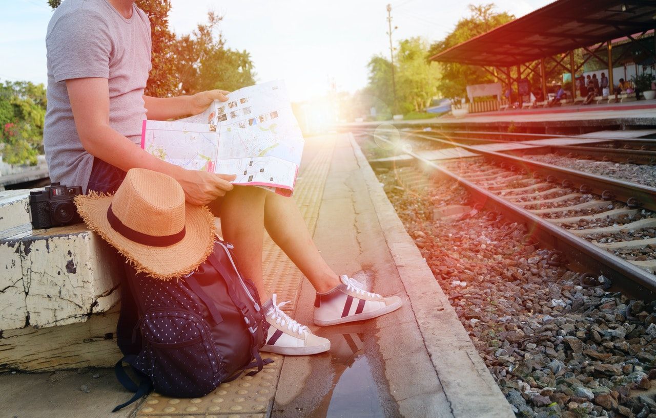 man sitting next to train tracks