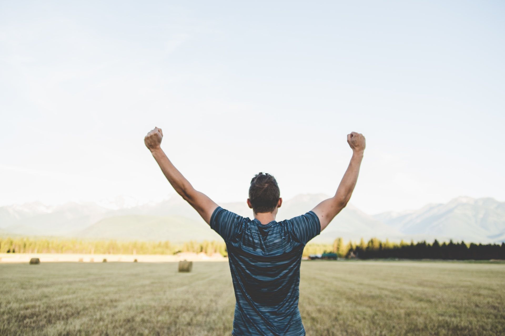 man from behind with two fists raised in victory