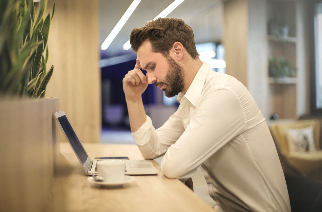 man sitting at desk contemplating