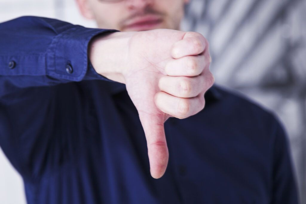 Rejection - close up of student's hand with a thumbs down