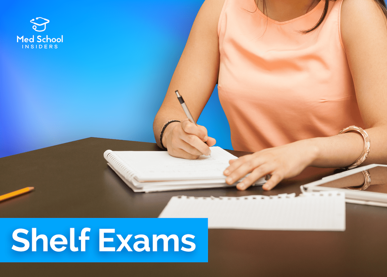 Medical student writing study notes in a notebook while preparing for a clinical shelf exam