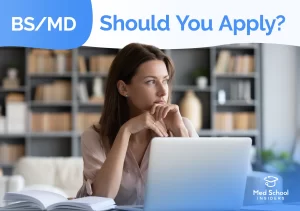 Student thinking while using a laptop, representing the decision of whether to apply to BS/MD programs.