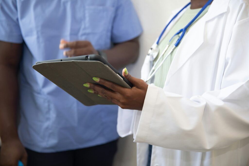 doctor in a clinical setting holding an ipad