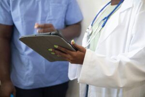 doctor in a clinical setting holding an ipad